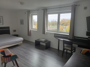 a bedroom with a bed and a desk and windows at Le Fitness & Business Studio - Airbus -Piscine Spa in Toulouse