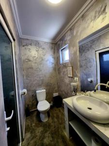 a bathroom with a toilet and a sink at Grand Bahia Relaxury in Costinesti +100 photos