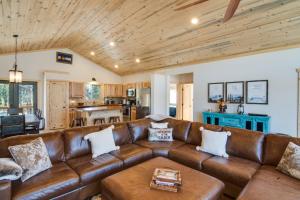 a living room with a brown leather couch at Quiet Mtn Cabin with Deck Less Than 5 Mi to Fairplay Beach! in Fairplay
