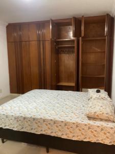 a bedroom with a bed and a refrigerator at Suíte privativa com cama Queen em casa ampla e confortável em casa compartilhada in Palhoça