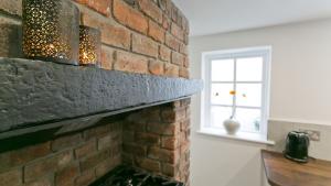 a brick fireplace in a room with a window at Beau Townhouse in Beaumaris +42 photos