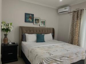 a bedroom with a bed and a vase of flowers at Summerfields & Gardens Lodge in Kitwe +97 photos