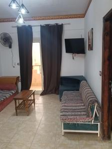 a living room with a couch and a tv at Blue lagoon resort in Ras Sedr