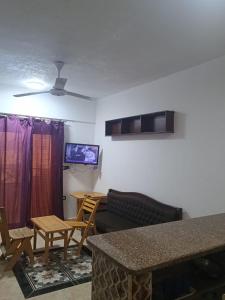 a living room with a couch and a table and a tv at Blue lagoon resort in Ras Sedr