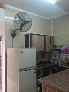 a kitchen with a refrigerator and a fan on the wall at Blue lagoon resort in Ras Sedr