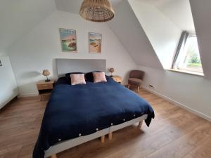 ラ・フォレ・フエナンにあるLes Pierres 2 Loc Amandのベッドルーム1室(屋根裏に青い大型ベッド1台付)