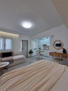 a white living room with a couch and a table at Hotel Andreas - Agistri (Skala) in Skala