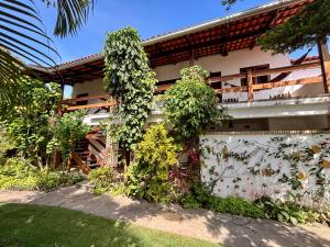 a building with plants on the side of it at Chez Max Pousada in Morro de São Paulo