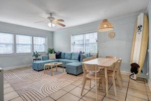 a living room with a blue couch and a table at Beachside Cottage Home - Short Walk to the Beach in Jacksonville Beach