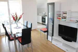 a dining room with a glass table and a television at Apartment Mihael in Cavtat