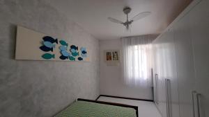 a room with a ceiling fan and a refrigerator at Quarto da Orla in Cabo Frio +11 photos