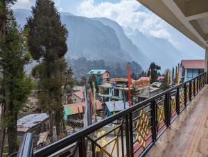 a balcony with a view of a town and a mountain at Hotel Endless Knot Lachung in Lachung