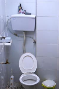La salle de bains est pourvue de toilettes blanches avec un tuyau au-dessus. dans l'établissement Modern & Serene 1 BR Getaway, à Eldoret