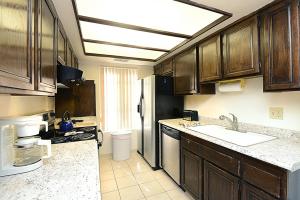 a kitchen with wooden cabinets and a sink at Ranch Club Getaway by Oranj Palm in Palm Springs