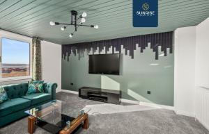ein Wohnzimmer mit Sofa und Fernseher in der Unterkunft Baffin Townhouse - INVOICE and REDUCED PRICE only via SUNRISE SHORT LETS DUNDEE, 3 bedrooms with 4 beds, Newly Refurbished, Fully Equipped, Free Parking, Amazing Views - Long Stays Available in Dundee