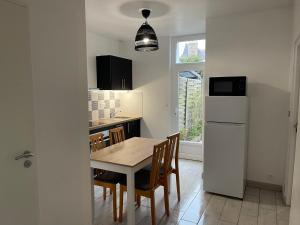 Una cocina y un comedor con mesa y sillas. en T3 St Malo- plage La Hoguette avec Jardin, en Saint-Malo