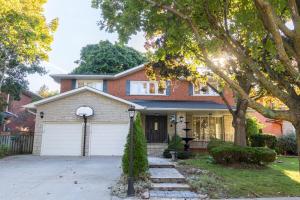 a brick house with a white garage at Majestic Mansion with Bar and Entertainment Space in Mississauga