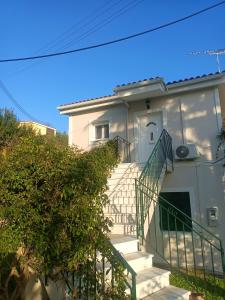a white house with stairs in front of it at Kommeno dream garden in Kommeno