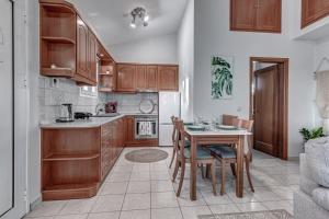 a kitchen with wooden cabinets and a table with chairs at Kommeno dream garden in Kommeno +6 photos