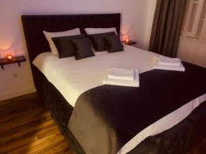 a bedroom with a large bed with two towels on it at D&B Apartment in Brčko