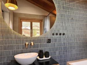 a bathroom with a sink and a mirror at BLUE ALPINE Lodge bis 6 Gäste, Cheminée, 400 m zum Skilift in Sedrun