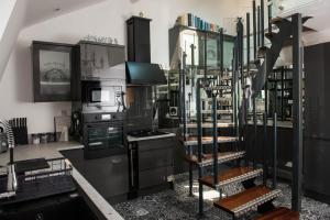 a kitchen with black and white appliances and shelves at The Penthouse in Kendal