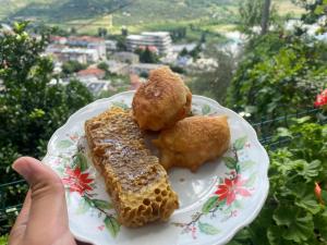a person holding a plate with food on it at Vila Përmbi Tepelenë in Tepelenë