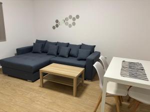 a living room with a blue couch and a table at Militari Comfort Apartment in Roşu