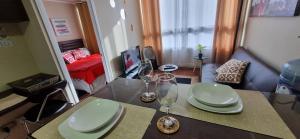 una mesa con platos y vasos encima en Departamento completo con Vista a la Ciudad, a pasos del Metro Santa Isabel, Barrio Italia, providencia, en Santiago