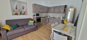 Una sala de estar con un sofá y una mesa y una cocina. en CasaGiòia, en Casagiove