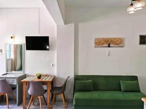 a living room with a green couch and a table at Valentino Studio Kalymnos in Kalymnos