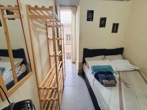een kamer met een bed en een kamer met een ladder bij Pequena Suíte Individual 304 in Rio de Janeiro +4 foto's
