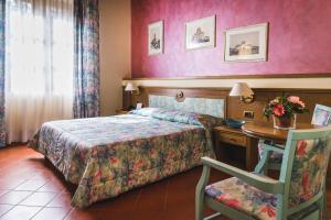 een hotelkamer met een bed, een tafel en een stoel bij Villa Sonnino in San Miniato