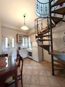 a kitchen and dining room with a spiral staircase at SyrasView in Ermoupoli