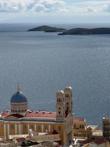 a building with a clock tower on top of the water at SyrasView in Ermoupoli