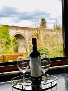 a bottle of wine and two wine glasses on a table at Siena COZY HOUSE in Siena