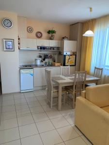 eine Küche und ein Esszimmer mit Tisch und Stühlen in der Unterkunft Harmony Hills Tomovi Apartment K32 in Rogachevo
