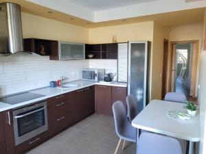 a kitchen with brown cabinets and a table with chairs at Vaido apartamentai in Marijampolė