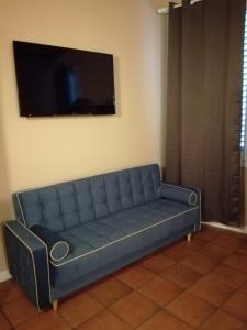 a blue couch in a room with a flat screen tv at PIAZZA CAVOUR 2 LUXURY ROOMS- BEDINBOLOGNACENTRO Suites in Bologna