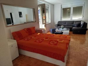 a bedroom with a large bed and a couch at VILA RUŽA - Grand apartman 2 in Soko Banja