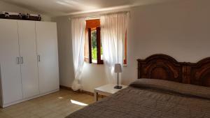 un dormitorio con una cama y una ventana en Villa Anna - Mansarda vista mare con giardino e patio, en Marina di Fuscaldo