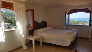 Un dormitorio con una cama y una ventana grande. en Villa Anna - Mansarda vista mare con giardino e patio, en Marina di Fuscaldo 14 fotos más