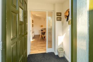 威特尼Bumble Bee Bungalow Serviced Accommodation的走廊上设有绿门和用餐室