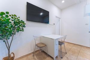 a room with a table and a tv on a wall at La Bella Vita Bergamo with free private parking in Bergamo +17 photos