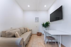 a living room with a couch and a tv on a wall at La Bella Vita Bergamo with free private parking in Bergamo