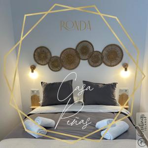 een slaapkamer met een bed met een bordje aan de muur bij Casa Peñas 2 in Ronda