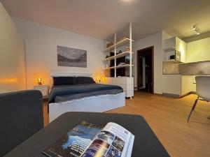 a bedroom with a bed and a living room at Riva&Lago Gravedona - Larihome A90 in Gravedona