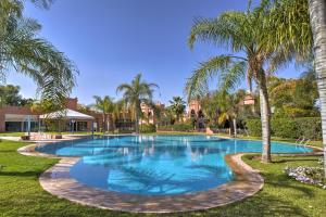 a swimming pool with palm trees around it at VILLA Garden in Marrakesh