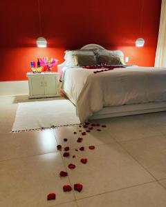 a bedroom with red walls and a bed with roses on the floor at Chalé Banho de Floresta Atibaia Clube de Montanha in Atibaia