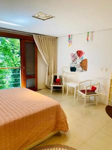 a bedroom with a bed and a table and chairs at Chalé Banho de Floresta Atibaia Clube de Montanha in Atibaia